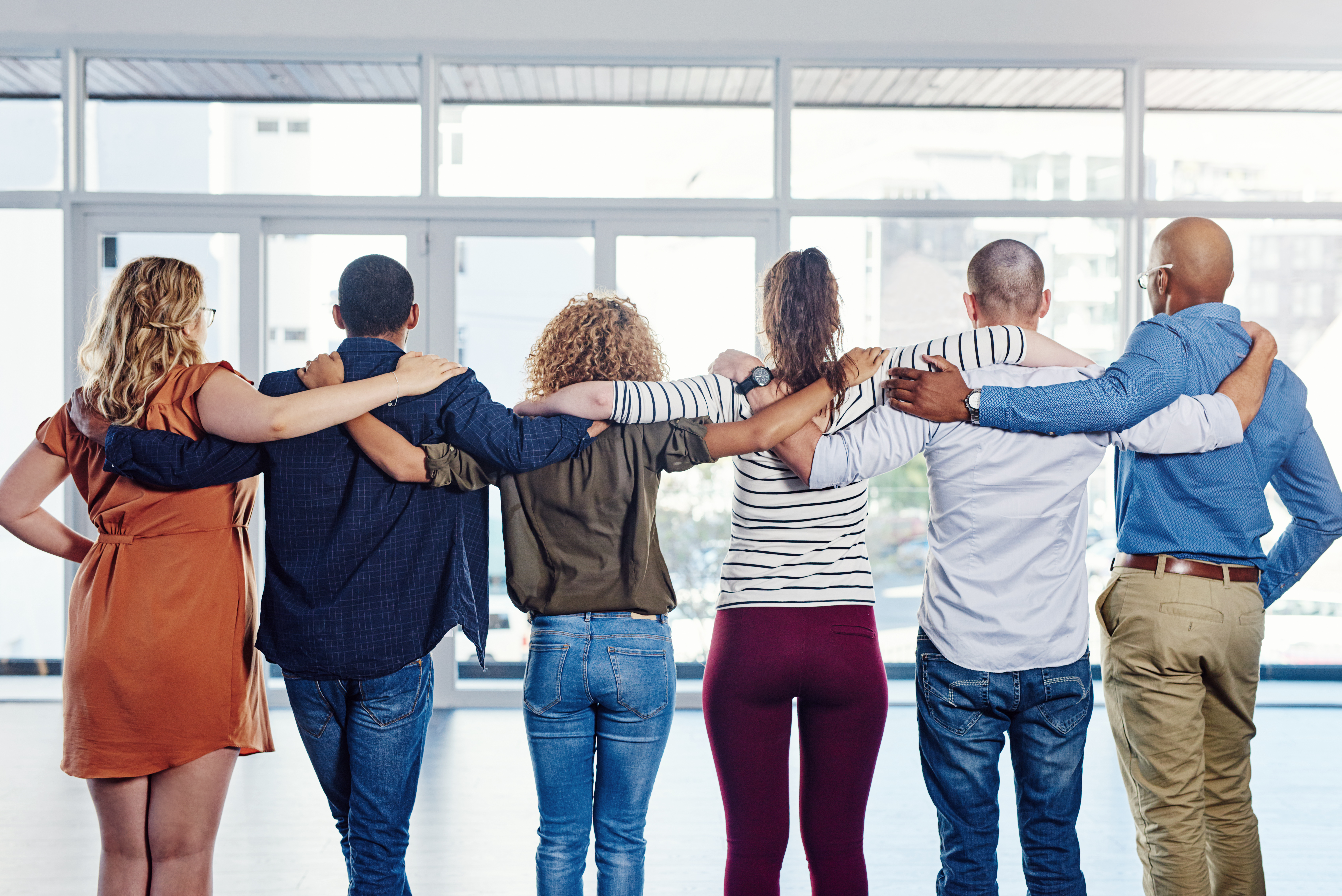 People in a line with arms around each others back