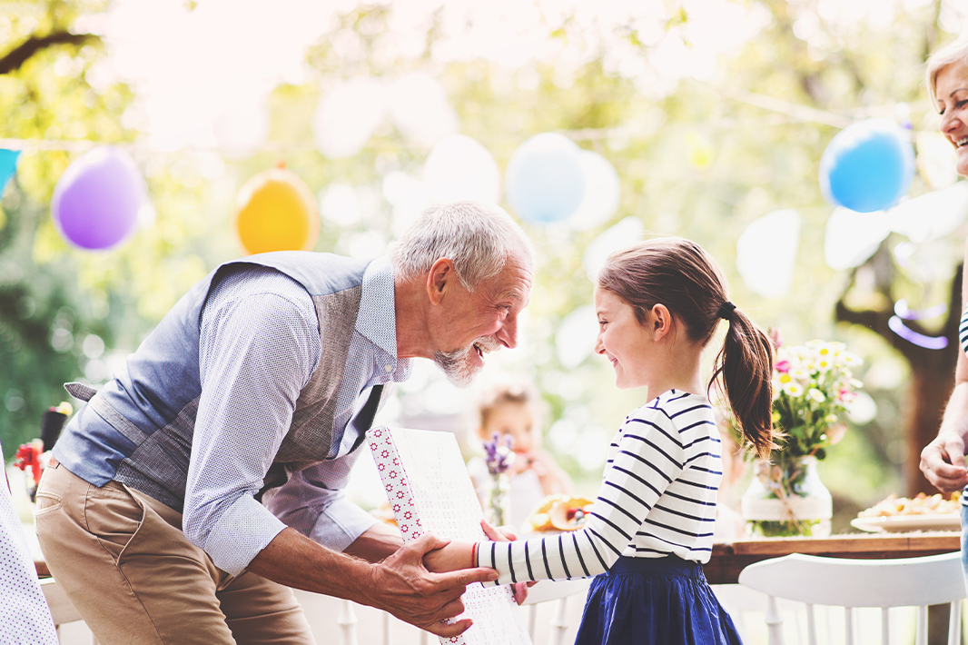 Older man with young girl celebrating at a party 